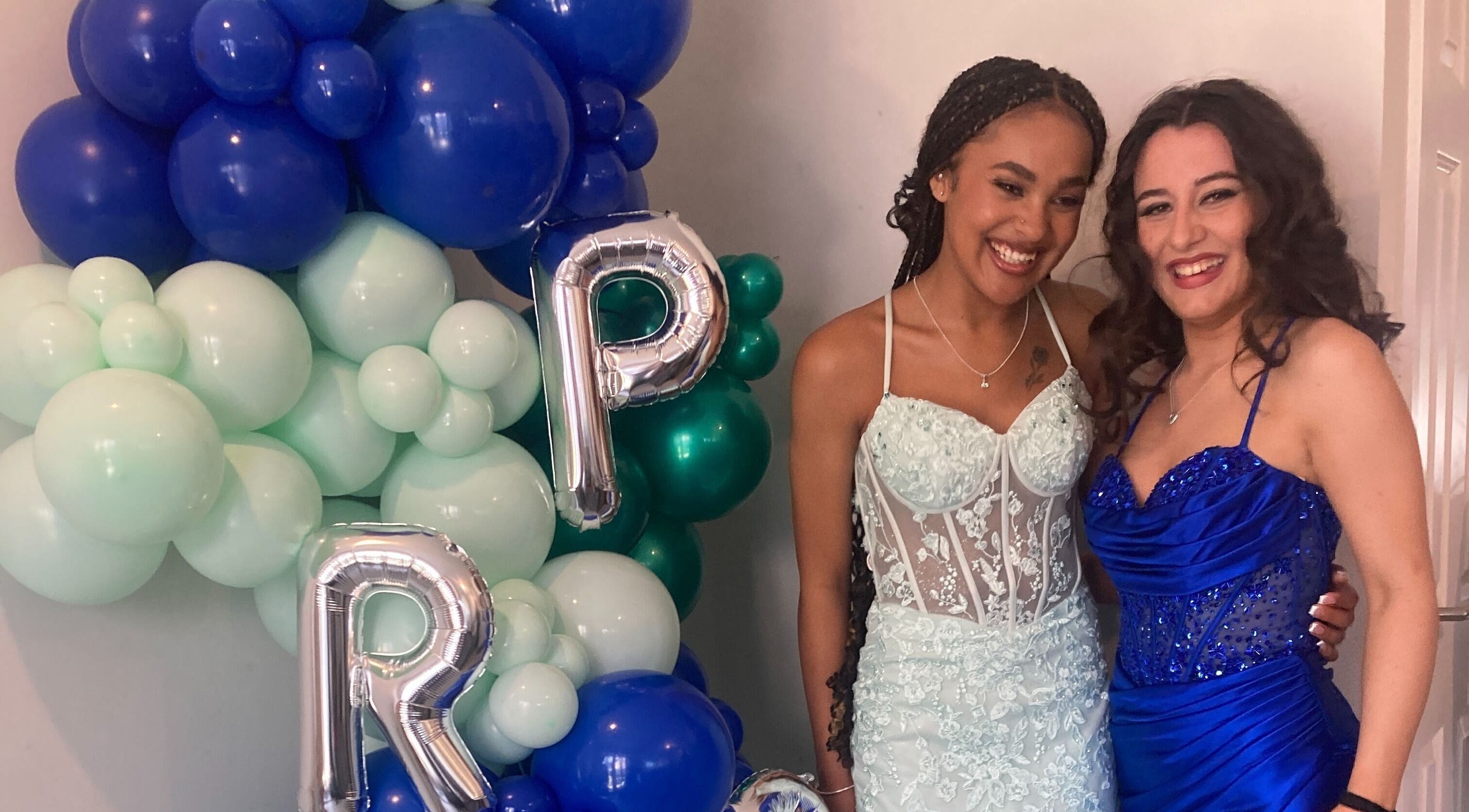 Two women in elegant dresses at Rita DeSario Make-Up Artist, Southampton, England, GB, with festive balloons.