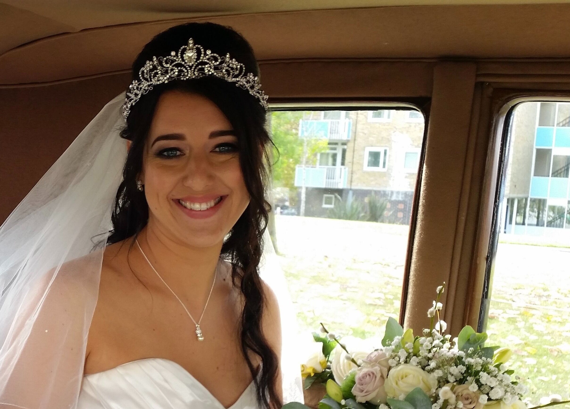 Smiling bride with tiara and bouquet at Rita DeSario Make-Up Artist in Southampton, England, GB.