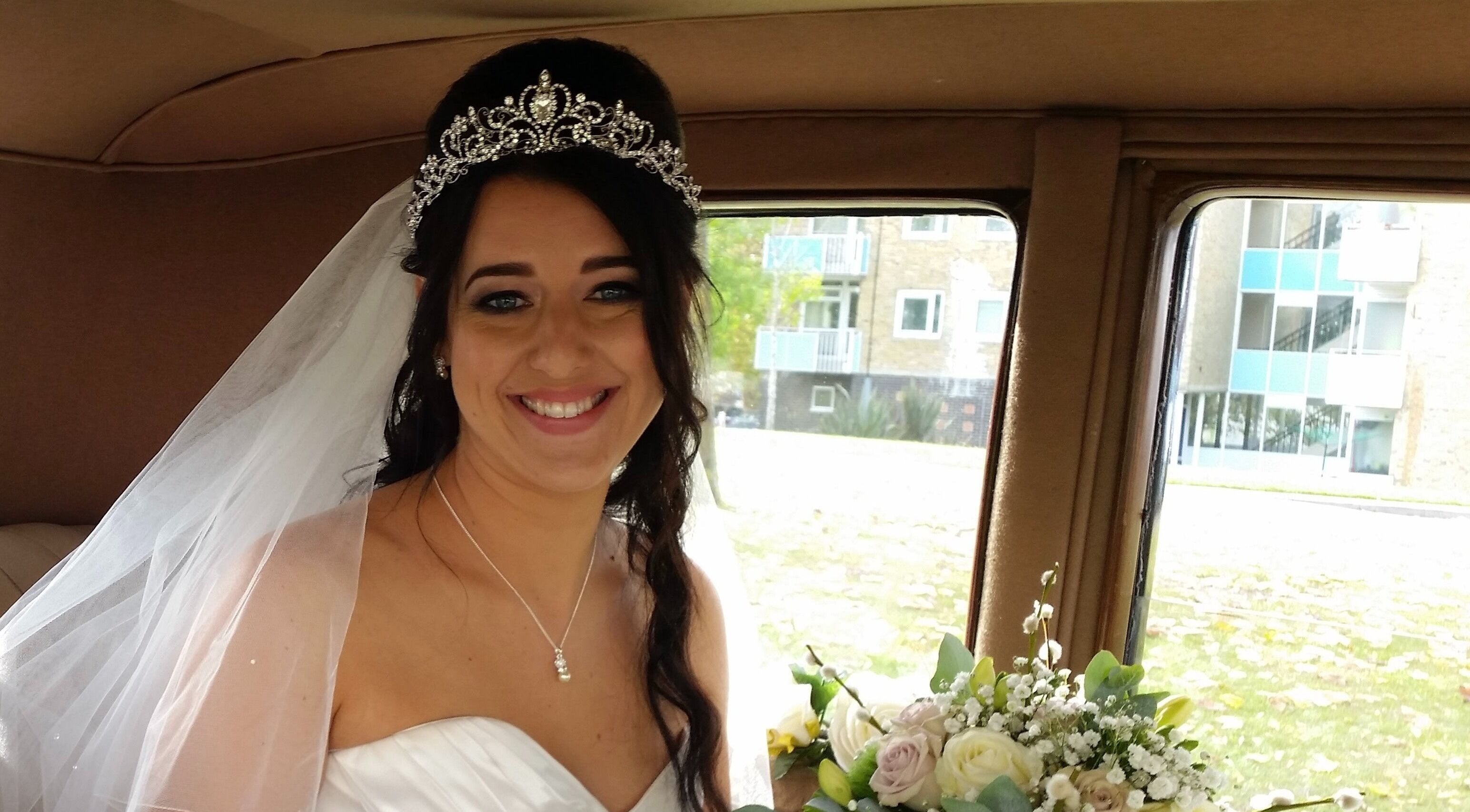 Smiling bride with tiara and bouquet at Rita DeSario Make-Up Artist in Southampton, England, GB.
