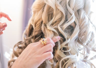 Stylist crafting elegant curls at Rita DeSario Make-Up Artist, Southampton, England, GB.