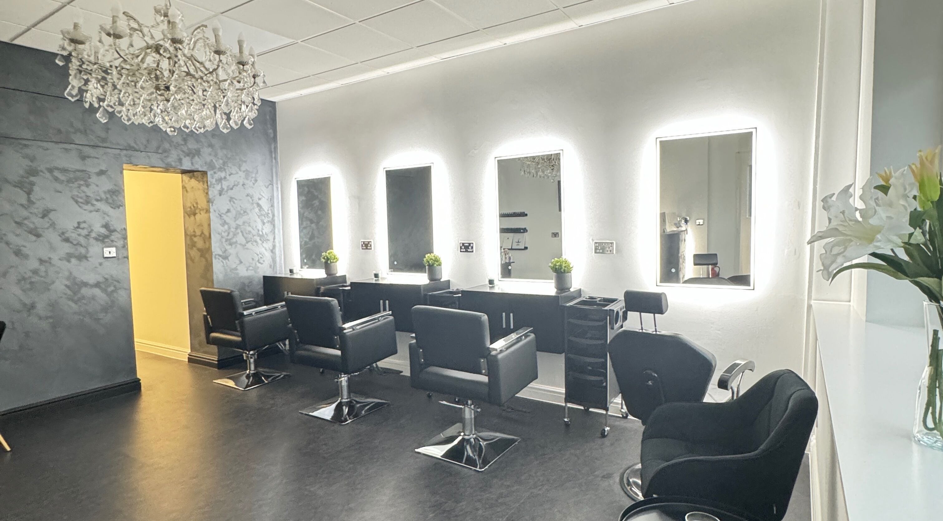 Elegant interior of Studio One Hair & Beauty in Jarrow, England, featuring stylish salon chairs and illuminated mirrors.