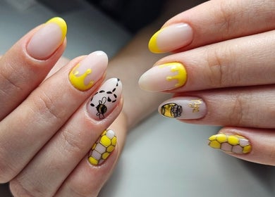 Bee-themed nail art at Elegant Nails, Cardiff, Wales, GB. Showcases intricate yellow and black designs.