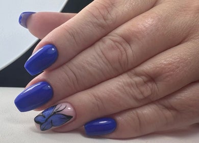 Blue manicured nails with a butterfly design at Elegant Nails, Cardiff, Wales, GB.
