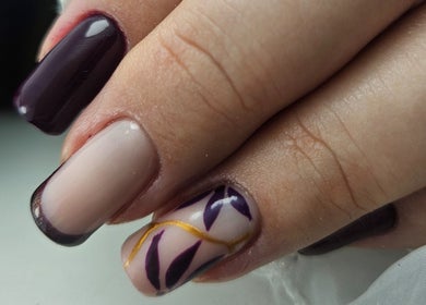 Elegant Nails' creative nail art in Cardiff, Wales, GB featuring dark and light polish with leaf design.
