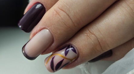 Elegant Nails' creative nail art in Cardiff, Wales, GB featuring dark and light polish with leaf design.
