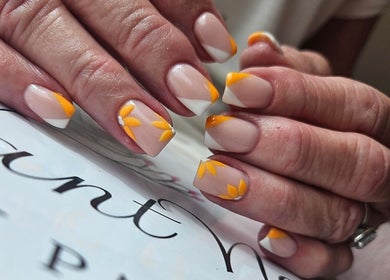 Elegant Nails showcases floral nail art with orange accents in Cardiff, Wales, GB.