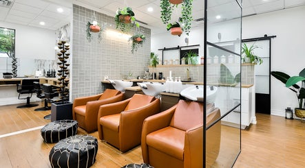 Intérieur moderne de Centre Sante du Cheveu à Rosemère, Québec, CA avec fauteuils en cuir et plantes suspendues.