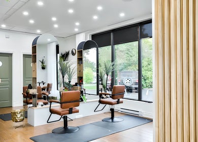 Intérieur moderne du Centre Sante du Cheveu à Rosemère, Québec, CA avec sièges en cuir et grandes fenêtres.