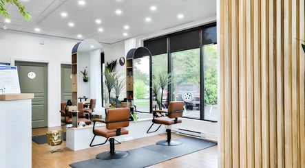 Intérieur moderne du Centre Sante du Cheveu à Rosemère, Québec, CA avec sièges en cuir et grandes fenêtres.