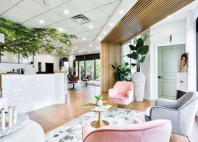 Intérieur élégant du Centre Sante du Cheveu à Rosemère, Québec, CA, avec fauteuils et verdure luxuriante.