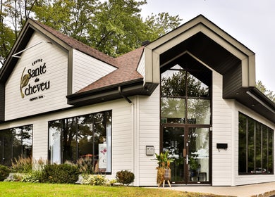 Façade moderne du Centre Santé du Cheveu à Rosemère, Québec, CA avec de grandes fenêtres et nature environnante.