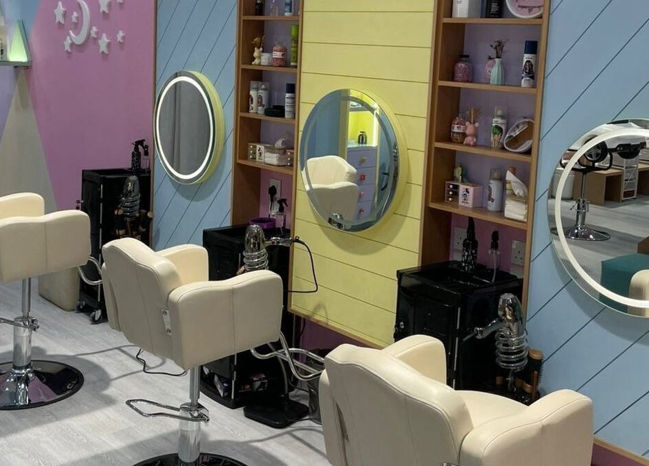 صالون بستايل الحمراء في السعودية، مقاطعة الرياض، SA بديكور مريح ومرآة دائرية أنيقة.