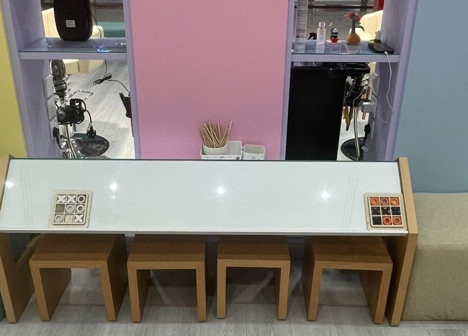 منطقة جلوس أنيقة في B-Style Al Hamra، السعودية، الرياض، SA مع كراسي خشبية وطاولة بيضاء.