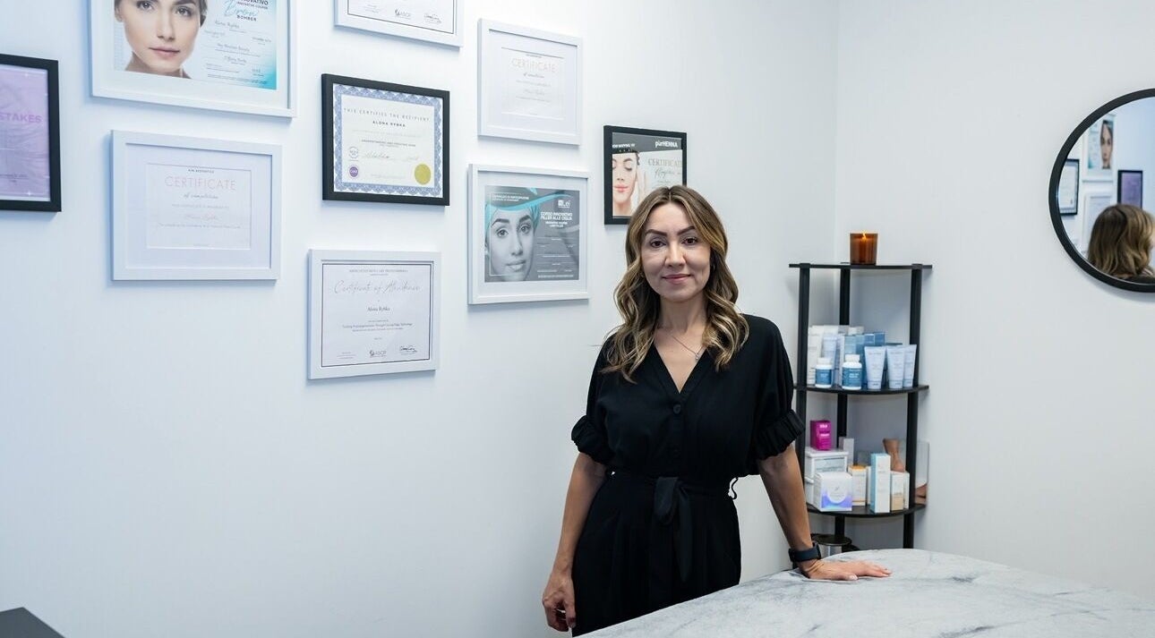 A beauty specialist at Face Essence Studio in Novato, California, US, stands by certificates in a serene treatment room.