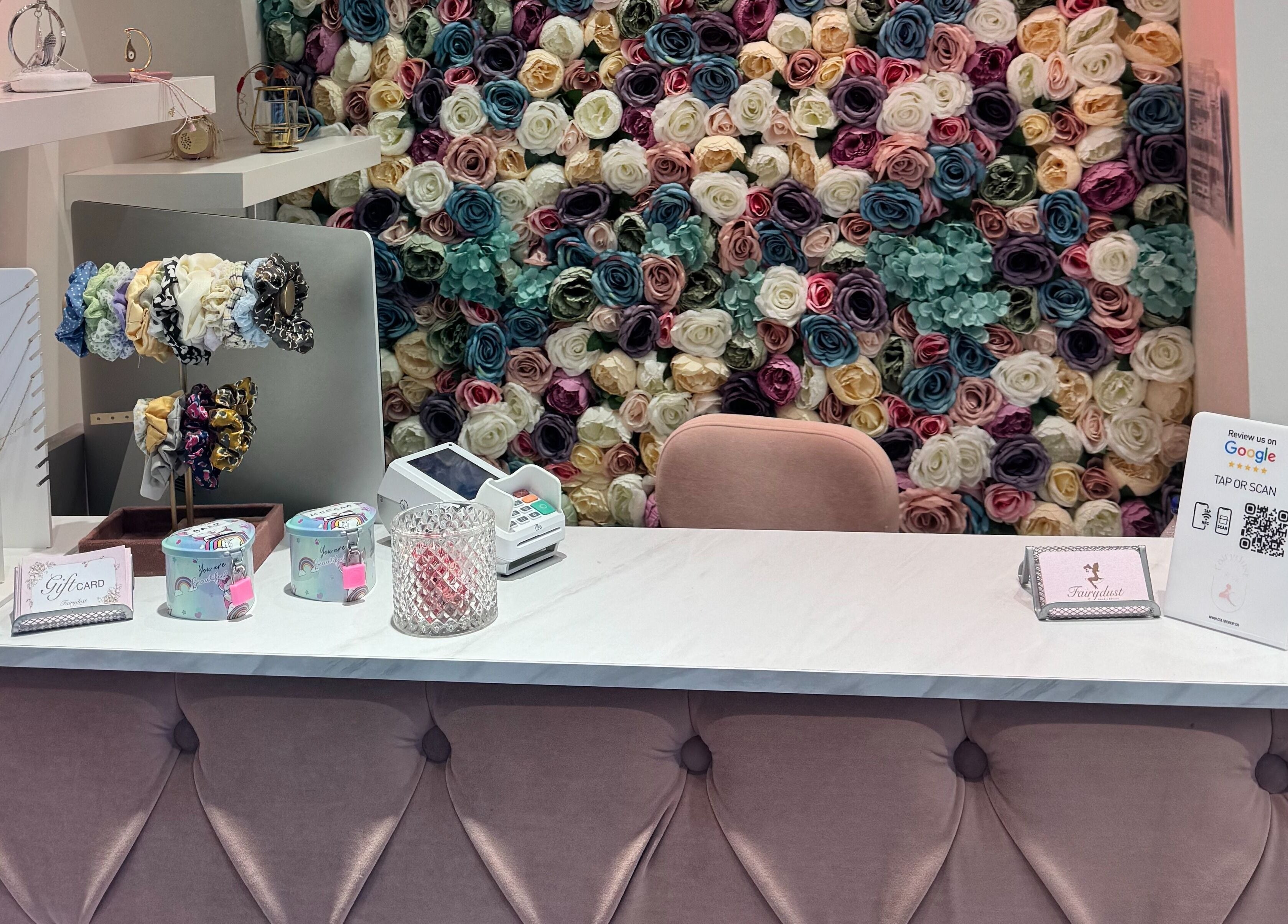 Reception desk at Fairydust in Βύρωνας, GR with floral wall and elegant decor.