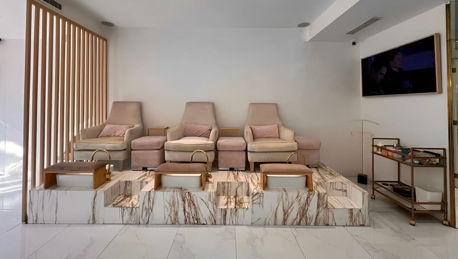 Zona de pedicura en Manee Beauty, Guadalajara, Jalisco, MX con sillas elegantes y tinas de mármol.