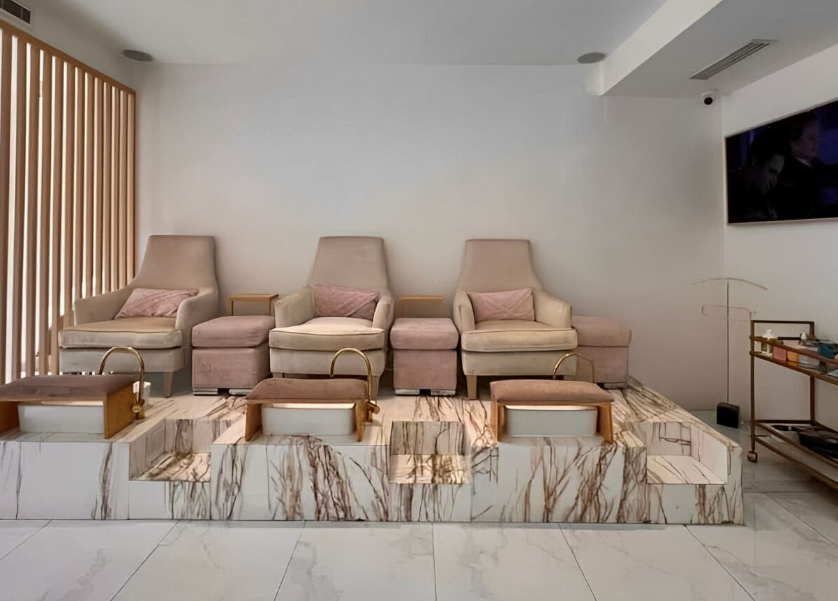 Zona de pedicura en Manee Beauty, Guadalajara, Jalisco, MX con sillas elegantes y tinas de mármol.