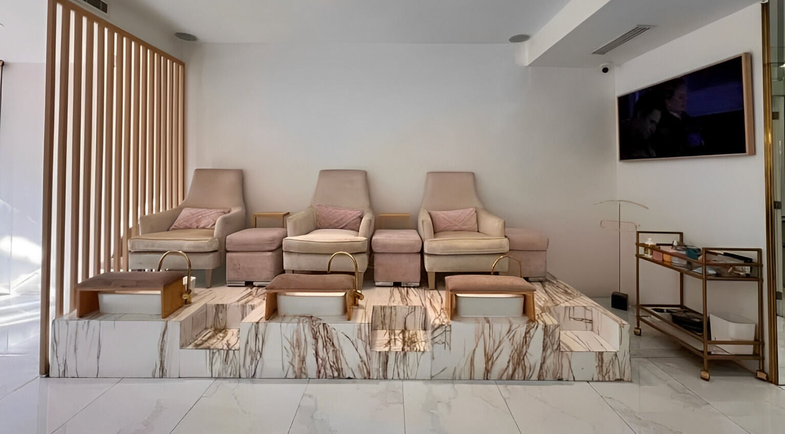 Zona de pedicura en Manee Beauty, Guadalajara, Jalisco, MX con sillas elegantes y tinas de mármol.
