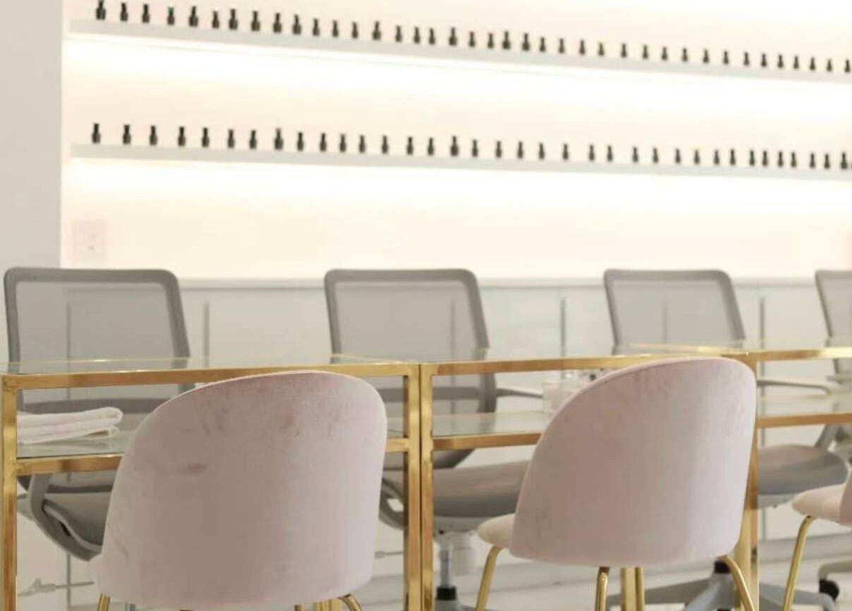 Interior moderno de Manee Beauty en Guadalajara, Jalisco, MX con sillas de terciopelo y mesas doradas.