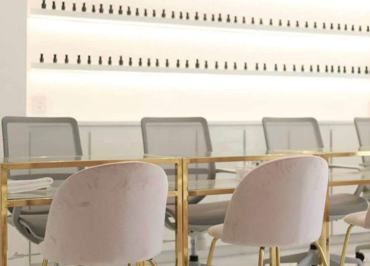 Interior moderno de Manee Beauty en Guadalajara, Jalisco, MX con sillas de terciopelo y mesas doradas.