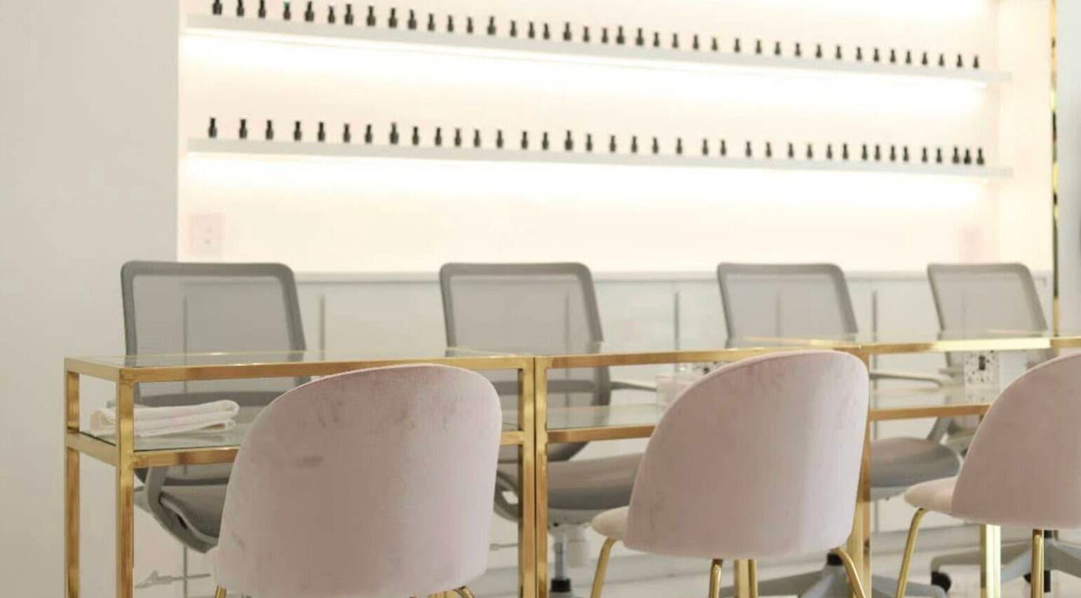 Interior moderno de Manee Beauty en Guadalajara, Jalisco, MX con sillas de terciopelo y mesas doradas.