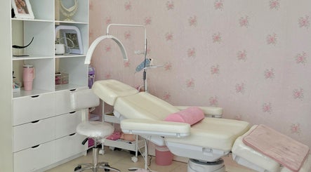 Sala de tratamiento en Beauté Studio, Chihuahua, MX con camilla y decoración en tonos rosados.