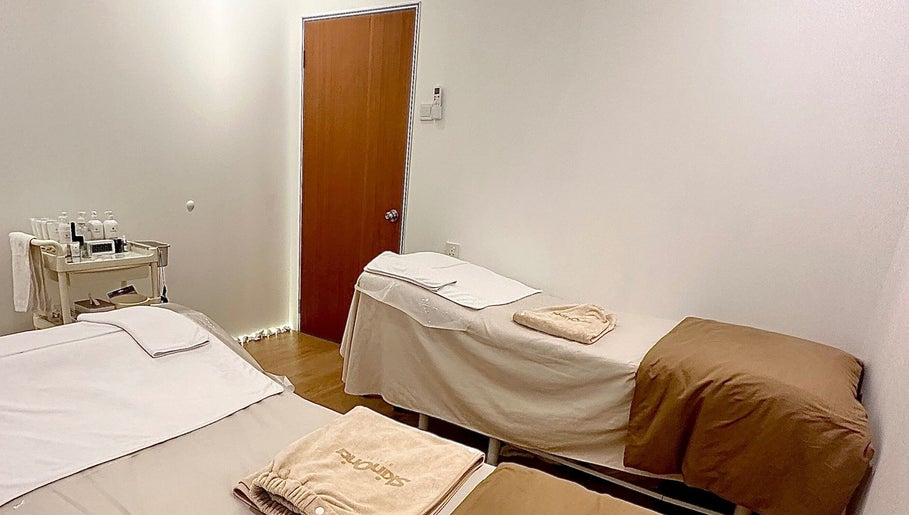 Calming therapy room at Skin Oria Beauty, Johor Bahru, featuring two massage beds and treatment essentials.