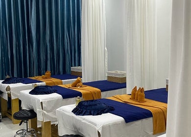 Phòng massage sang trọng tại Mer Spa Phu Quoc, Phú Quốc, Kiên Giang, VN với giường trắng và rèm xanh.