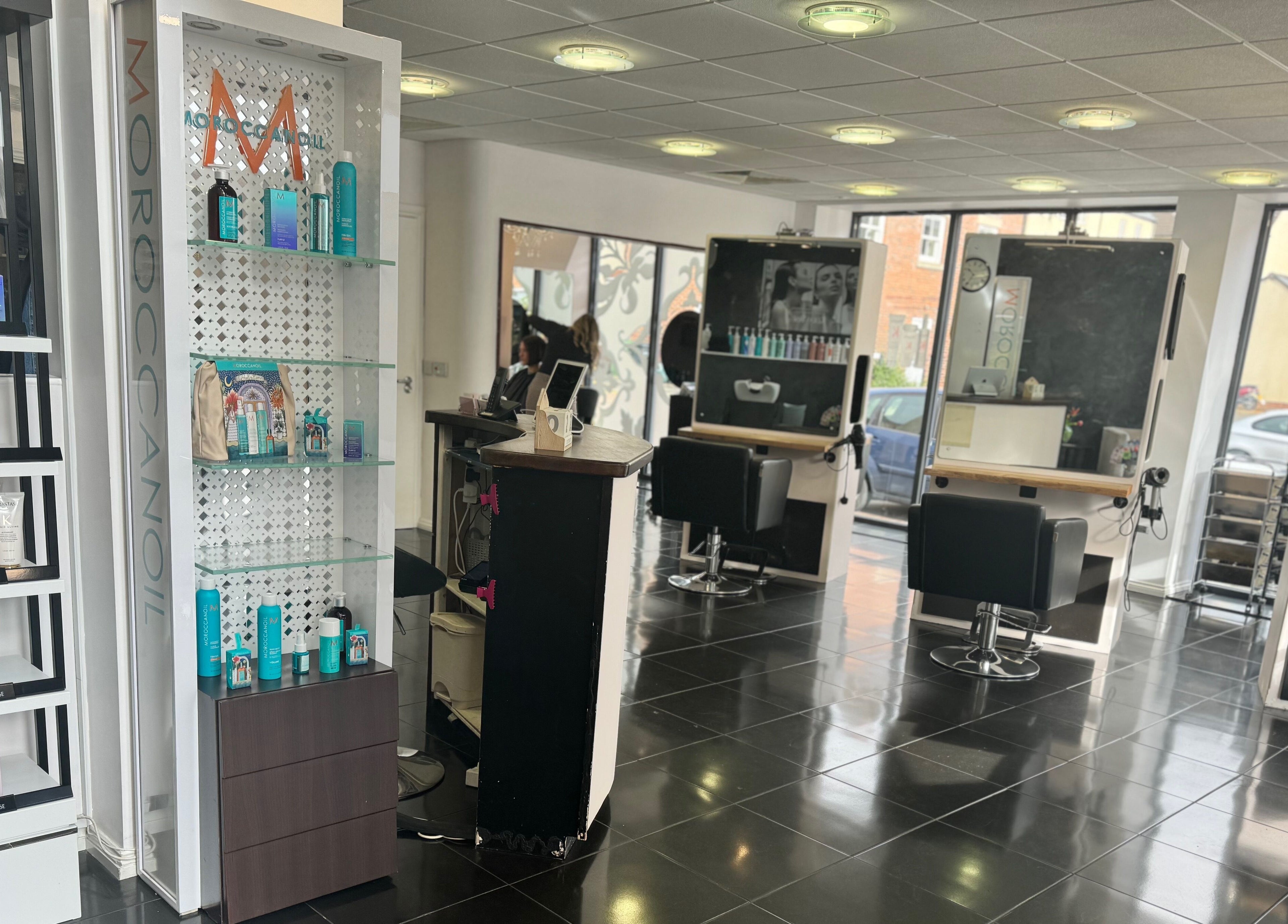Interior view of Studio 13 “A Salon Collective for Independent Stylists” in Ebley, England, GB featuring stylish chairs and products.