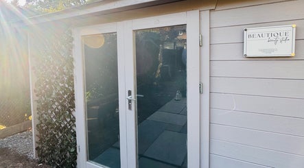 Entrance of Beautique Beauty Studio in Warninglid, England, GB with sunlight and greenery.