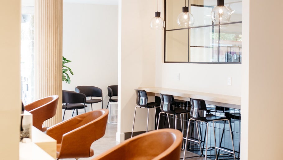 Élégant espace intérieur de Salon KANVA à Boisbriand, Québec, CA, avec sièges modernes et luminaires.