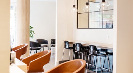 Élégant espace intérieur de Salon KANVA à Boisbriand, Québec, CA, avec sièges modernes et luminaires.
