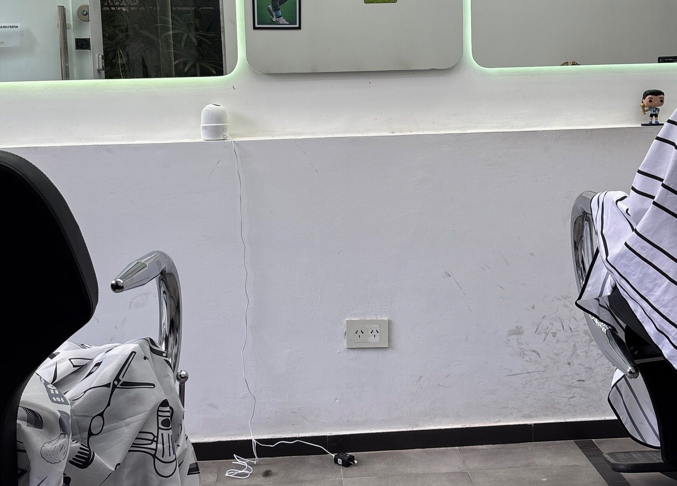 Interior elegante de Tutebarber en Buenos Aires, mostrando sillas de barbero y espejo amplio.