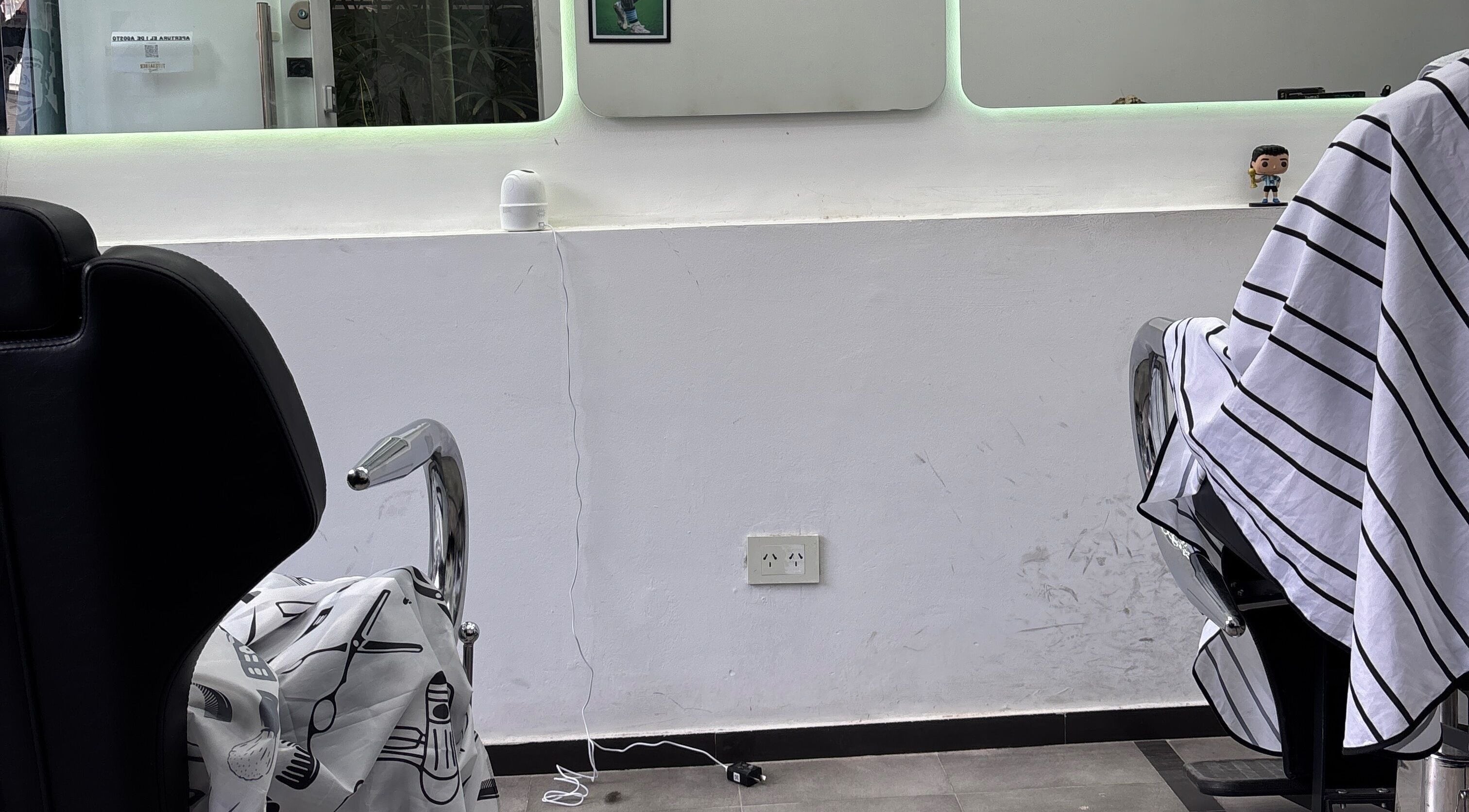 Interior elegante de Tutebarber en Buenos Aires, mostrando sillas de barbero y espejo amplio.