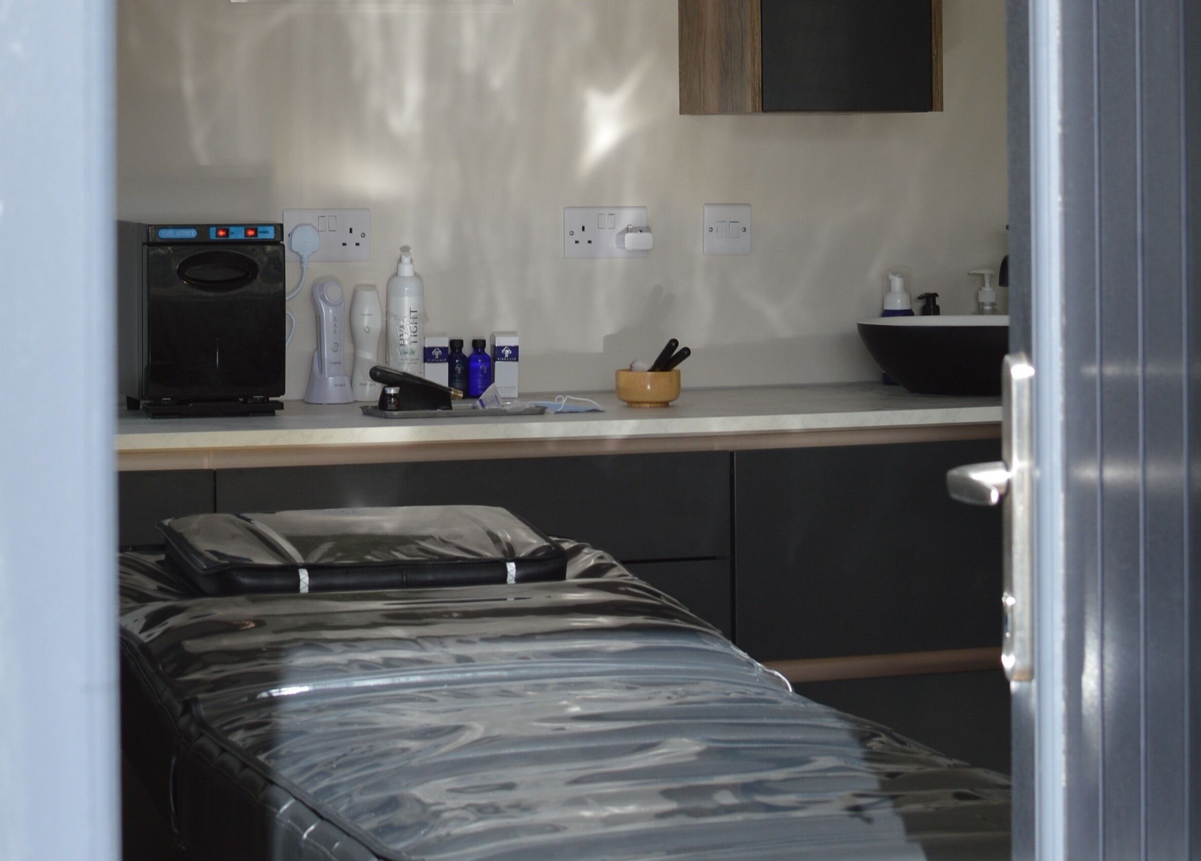 Tranquil therapy room at Next Gen Skin, Stoke-on-Trent, England, GB with massage table and skincare products.