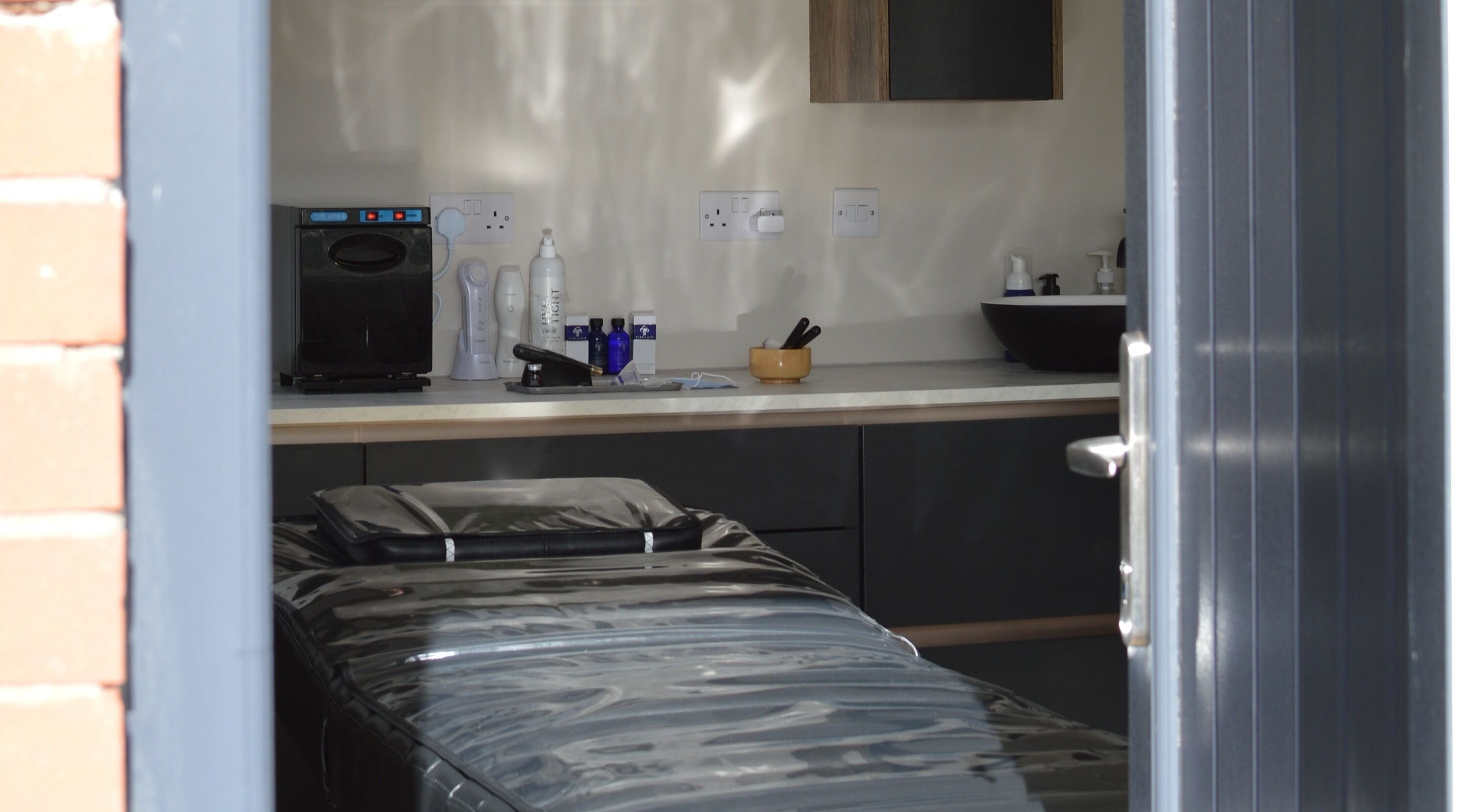 Tranquil therapy room at Next Gen Skin, Stoke-on-Trent, England, GB with massage table and skincare products.