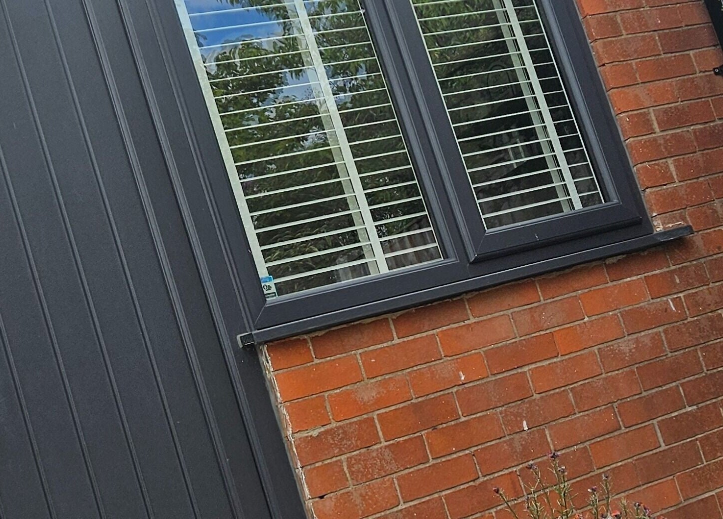 Modern exterior of Next Gen Skin venue in Stoke-on-Trent, England featuring sleek black door and window.