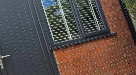 Modern exterior of Next Gen Skin venue in Stoke-on-Trent, England featuring sleek black door and window.