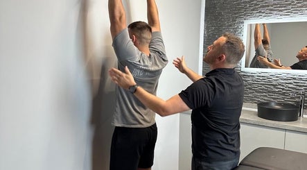 Therapist guides a patient at First Place Physiotherapy, Fleet, England, GB during a stretching session.