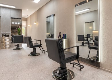 Modern styling chairs at Deevo Hair Salon, Melbourne, Victoria, AU, showcasing sleek interior design.