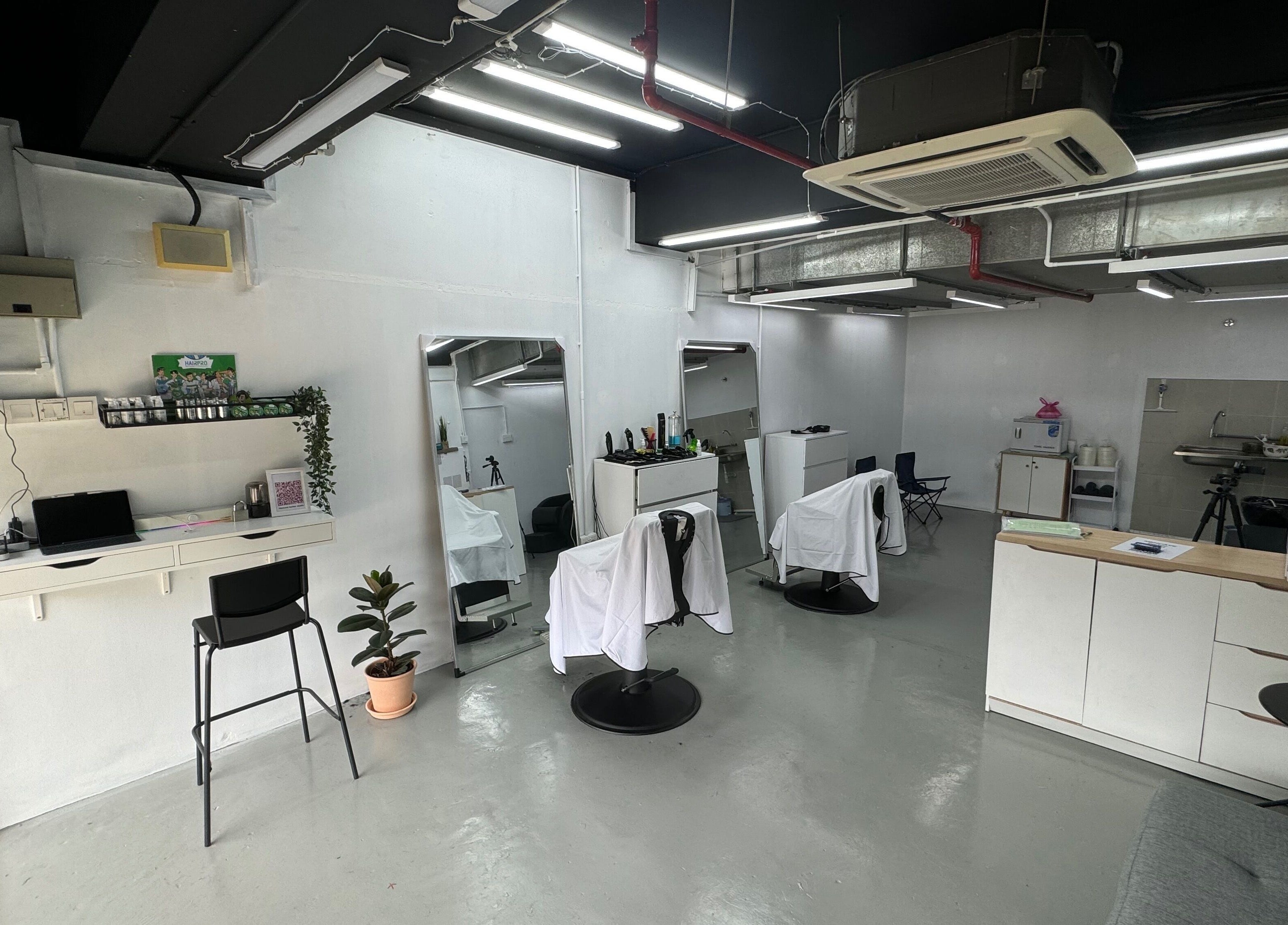 Interior of MENCAVE BARBER STUDIO in Shah Alam, Selangor, MY, featuring sleek chairs and minimalist decor.