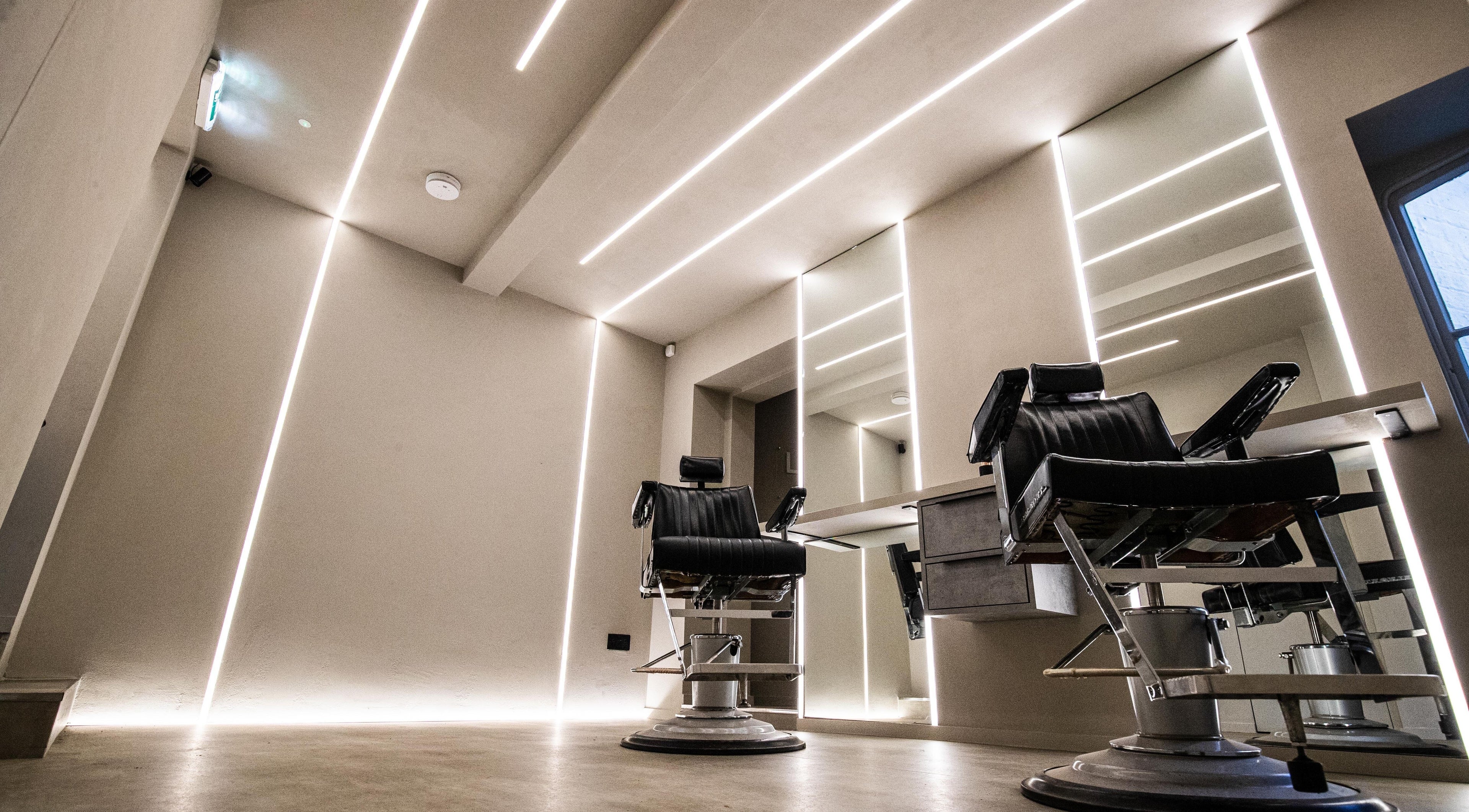 Sleek barber chair at Luchmun Studios in Hertford, England, GB with modern lighting and mirrors.
