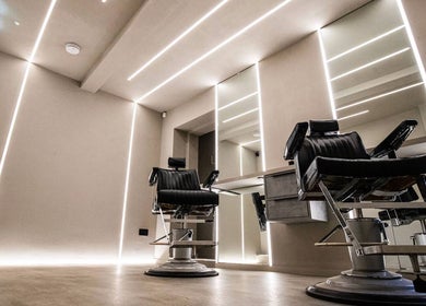 Modern barbershop chairs at Luchmun Studios Ware, England, GB, showcasing sleek interiors and mirrors.