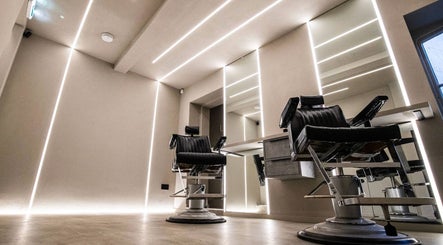 Modern barbershop chairs at Luchmun Studios Ware, England, GB, showcasing sleek interiors and mirrors.