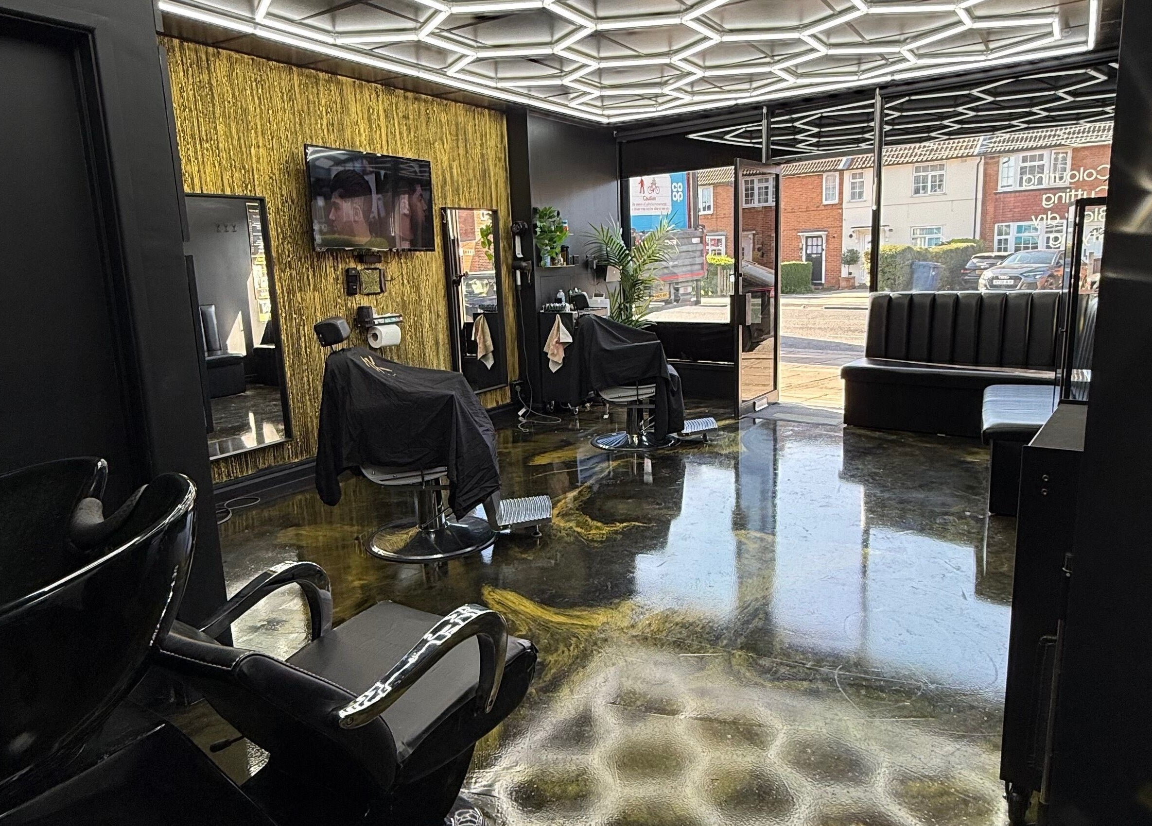 Chic interior of Jk The Barber Studios Limited in Edgware, England, GB with modern decor and styling chairs.