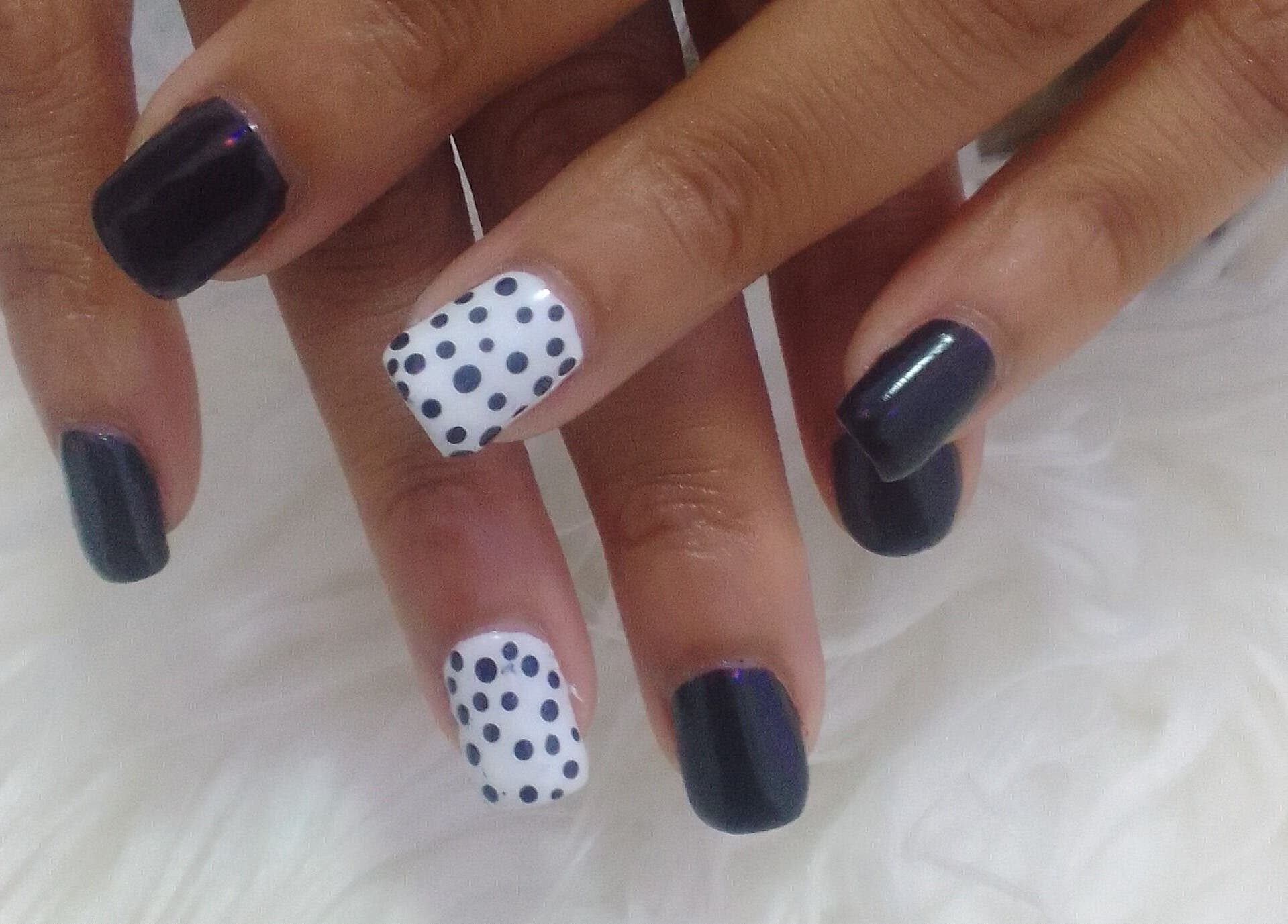 Nail art with dark polish and polka dots at Sharlon Beuti Bar, Cape Town, Western Cape, ZA.