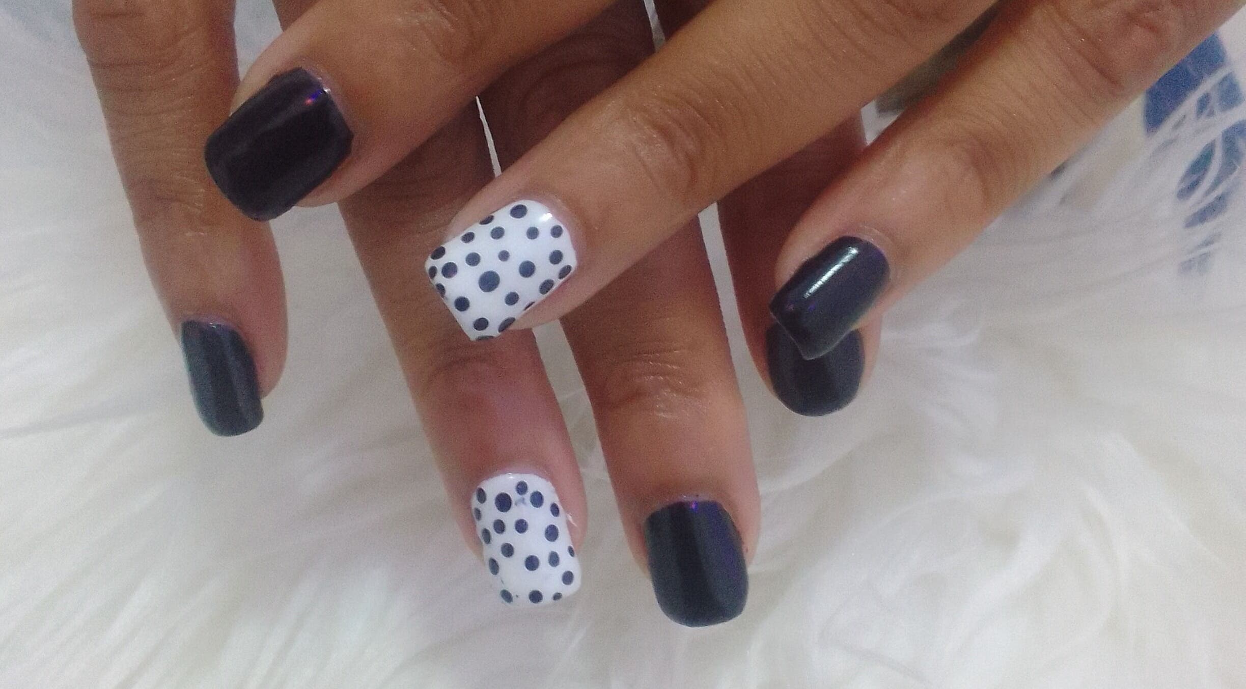 Nail art with dark polish and polka dots at Sharlon Beuti Bar, Cape Town, Western Cape, ZA.