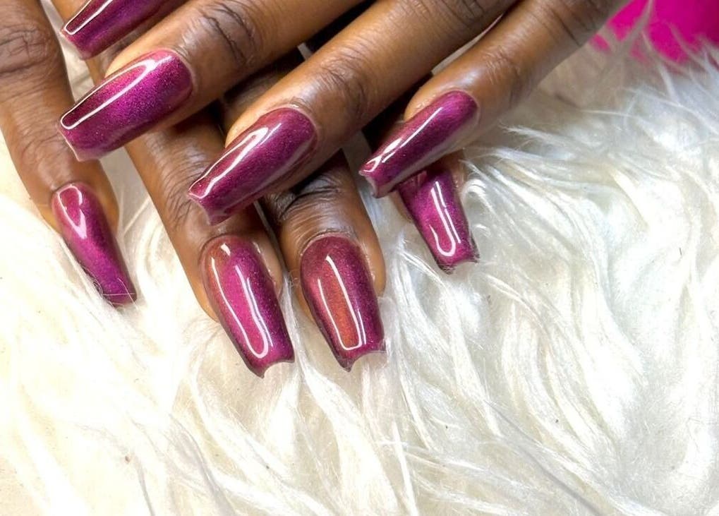 Elegant plum manicured nails at Sharlon Beuti Bar, Cape Town, Western Cape, ZA on a plush backdrop.