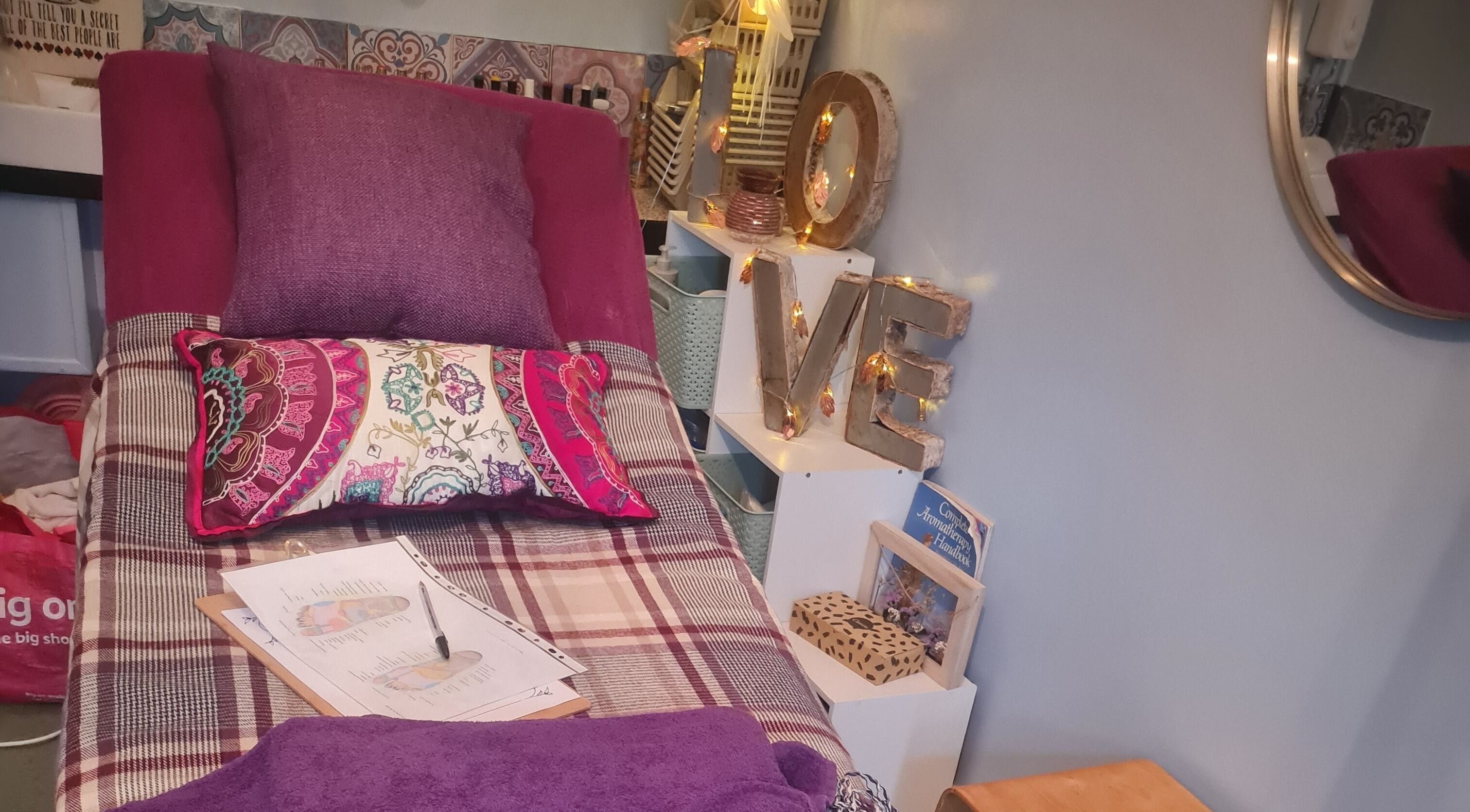 Cozy massage room at The Healing Garden Holistic Beauty, Newtown, Wales, GB, with plush pillows and decor.