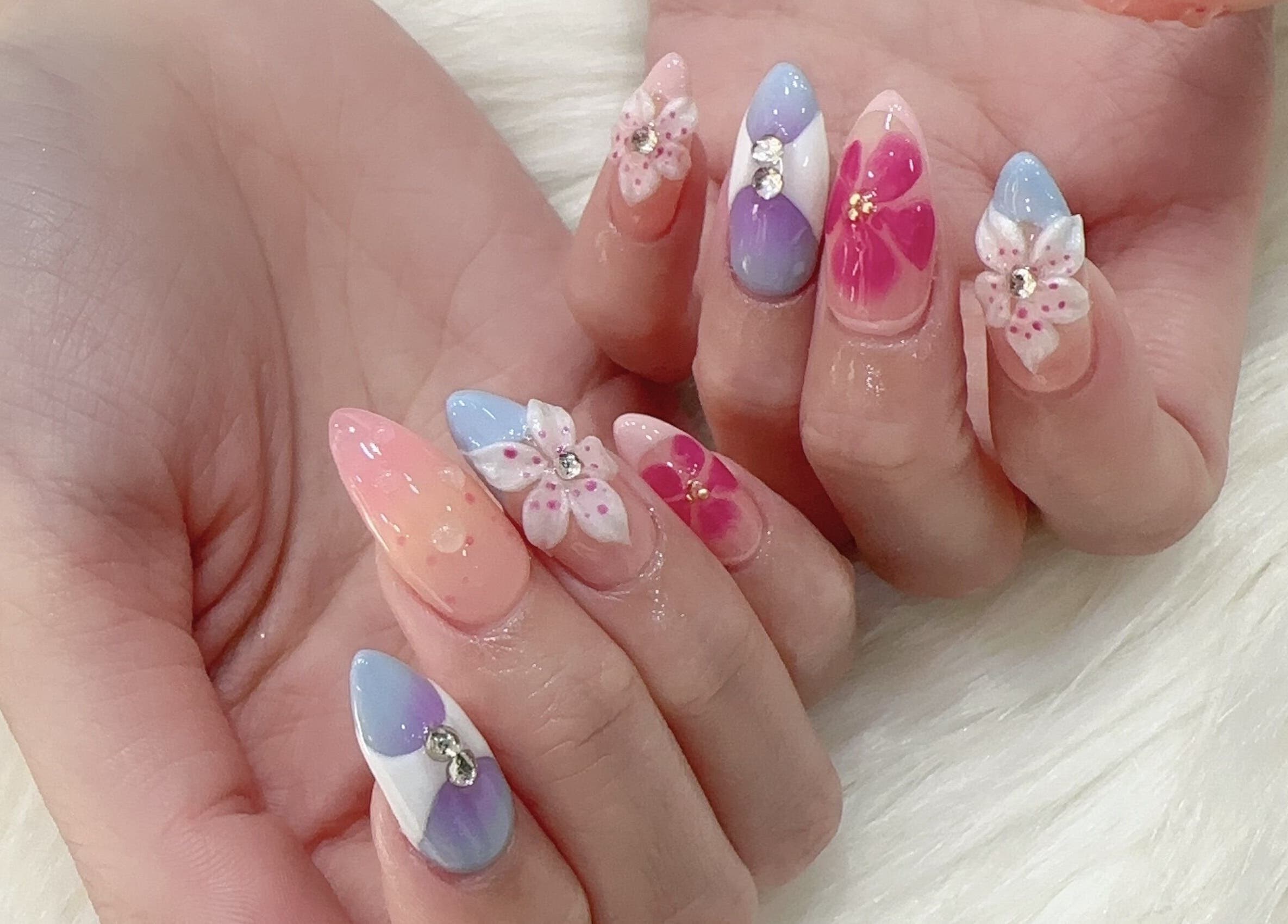 Elegant floral nail art at The Queenz, Singapore, SG, showcasing exquisite craftsmanship and beautiful pastel colors.